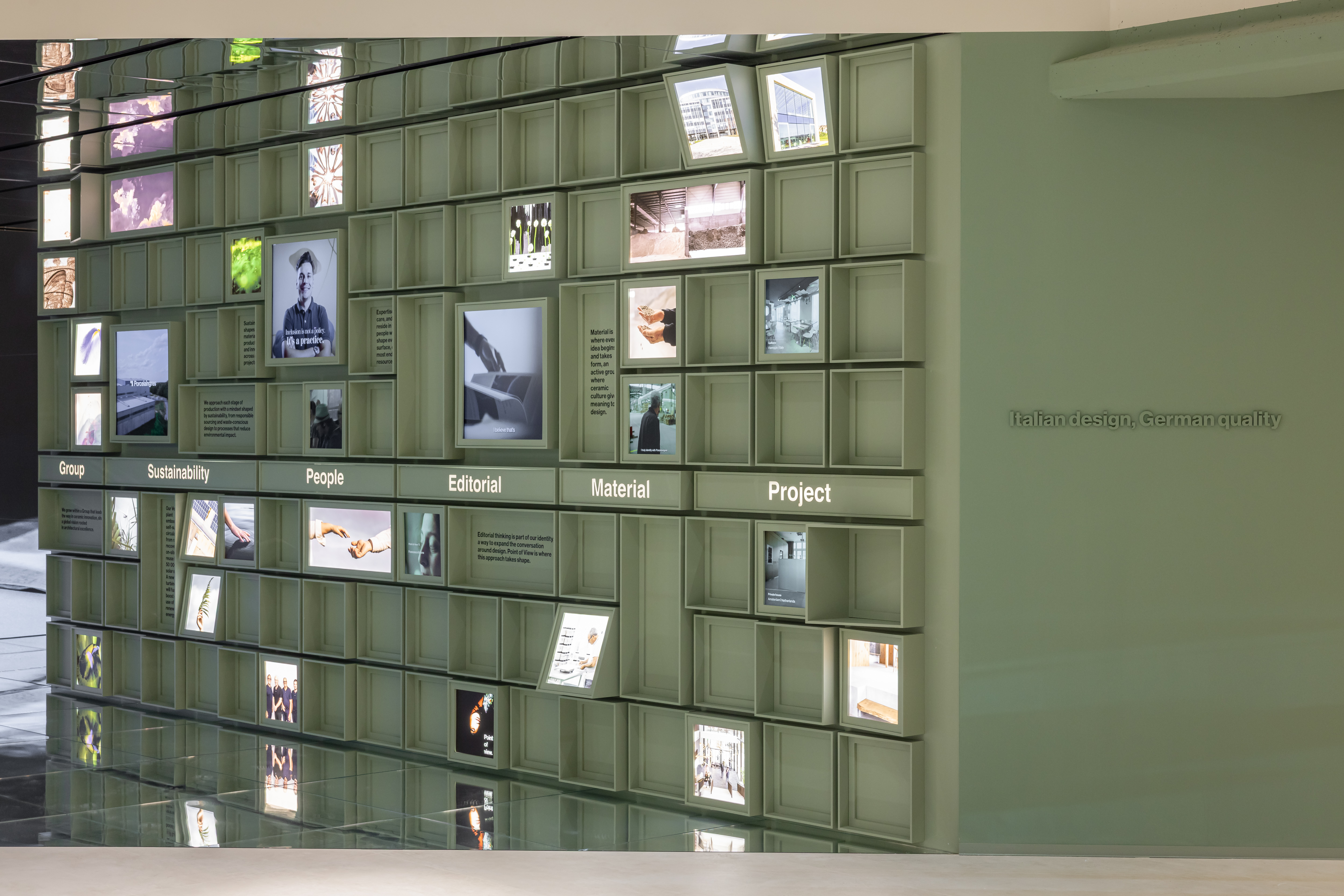 Parete espositiva illuminata di un marchio di piastrelle con focus su materiali e progetti.