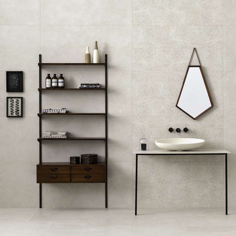 Bagno senza tempo con piastrelle effetto cemento chiare, di grande formato su pareti e pavimento.