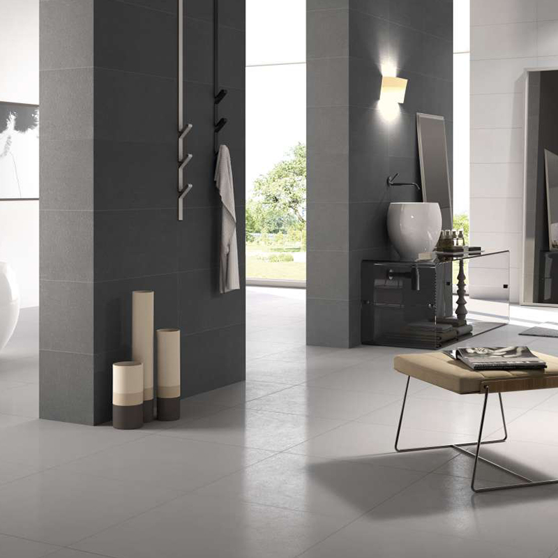 Bagno moderno con piastrelle grigio scuro alle pareti e grigio chiaro a pavimento.