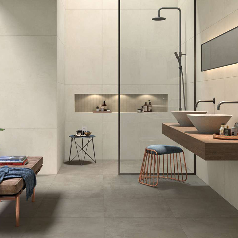 Bagno intramontabile con piastrelle di grande formato chiare e scure.