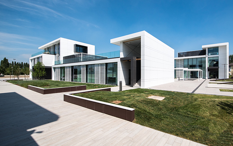 Elegante area esterna con piastrelle chiare di grande formato e moderni edifici.