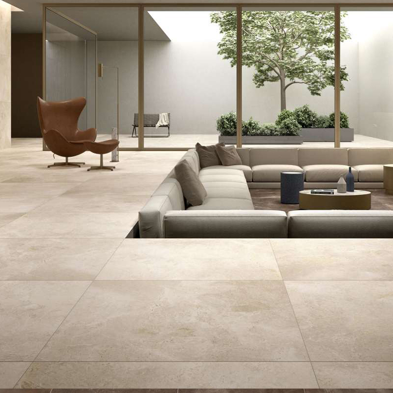 Piastrelle chiare e di grande formato creano una transizione fluida tra zona giorno interna e patio esterno.