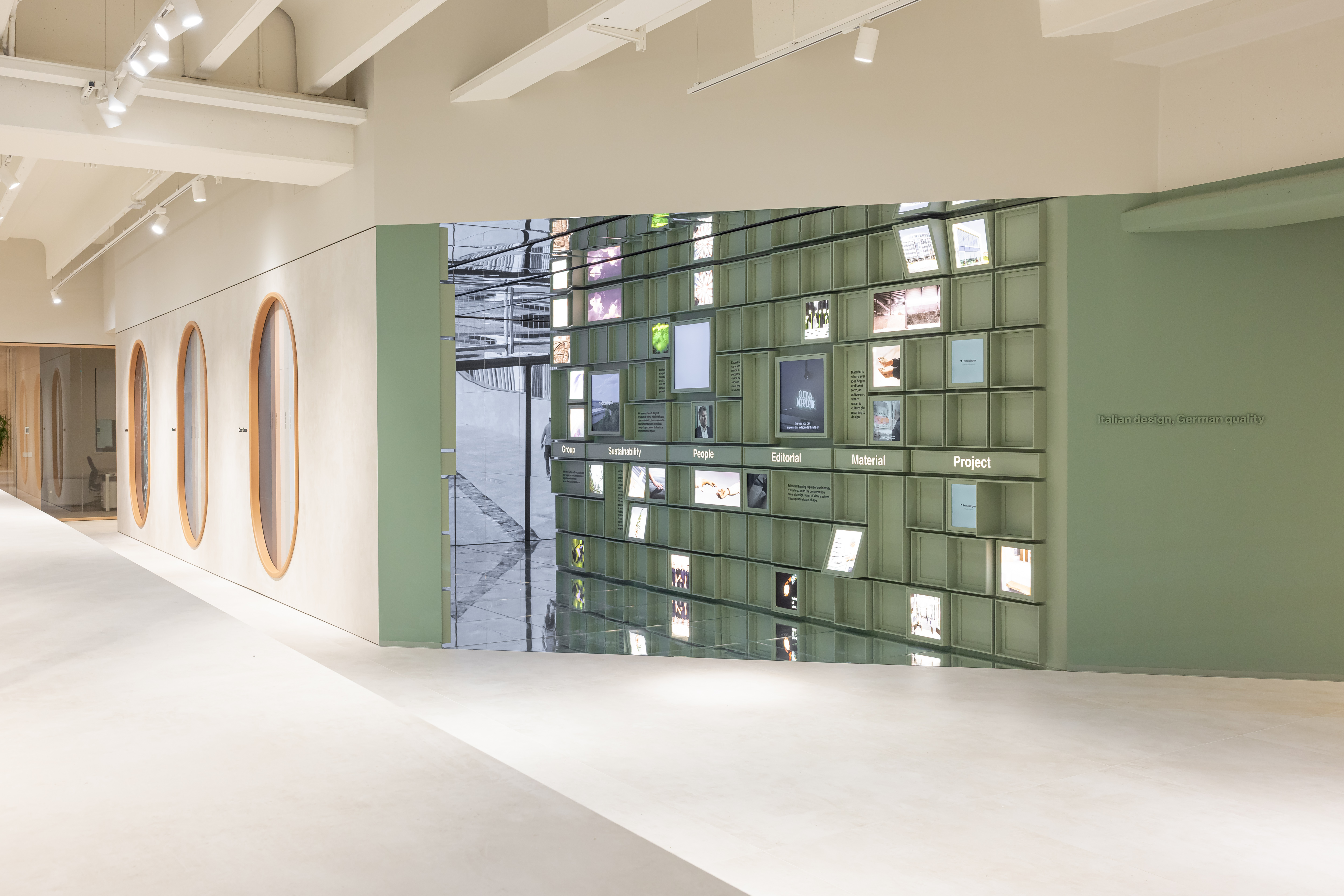 Moderno showroom con elegante parete espositiva verde per ispirazione piastrelle.