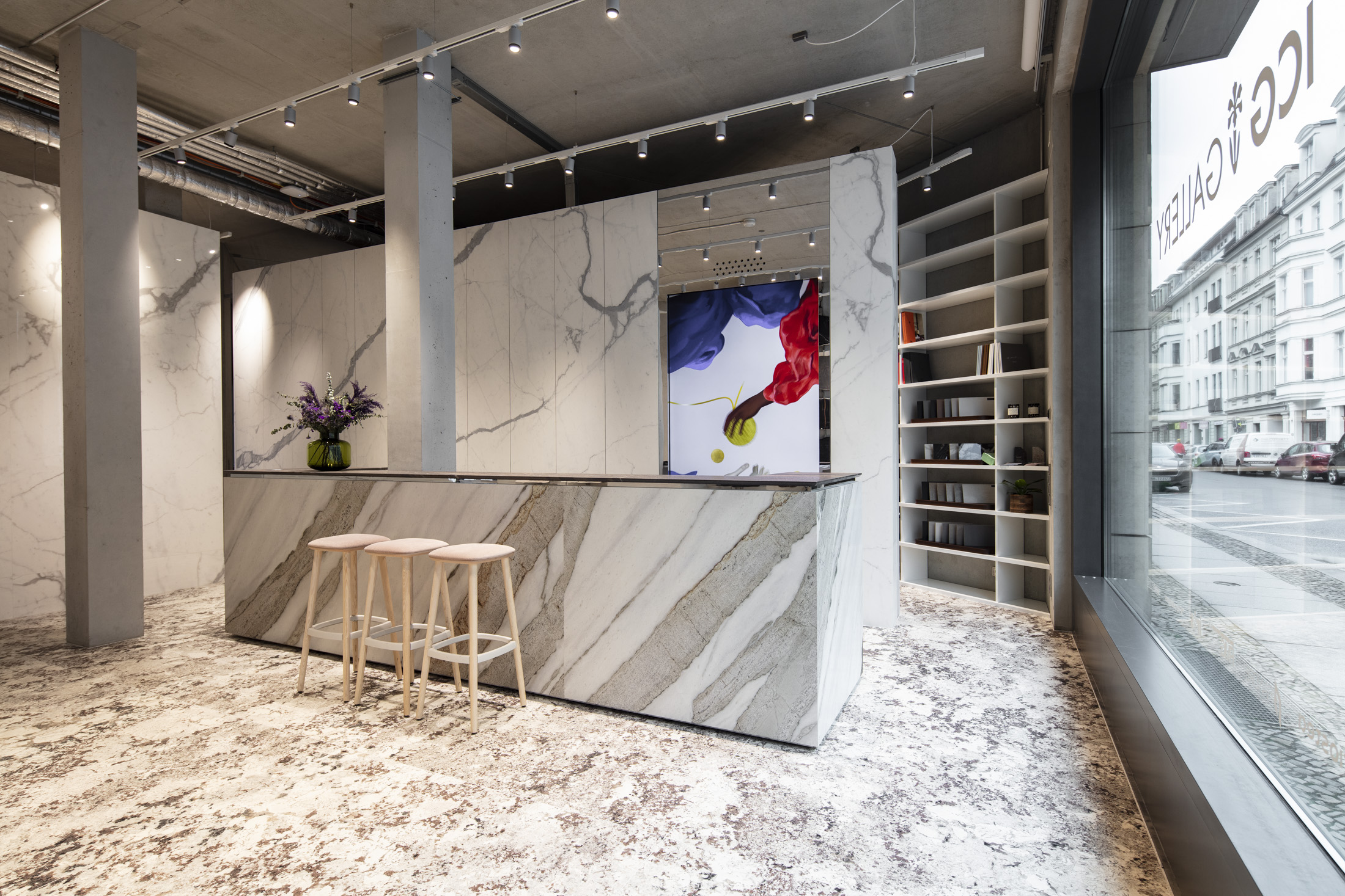 Idee d'arredo nello showroom piastrelle: piastrelle parete effetto marmo, pavimento strutturato e bancone elegante.