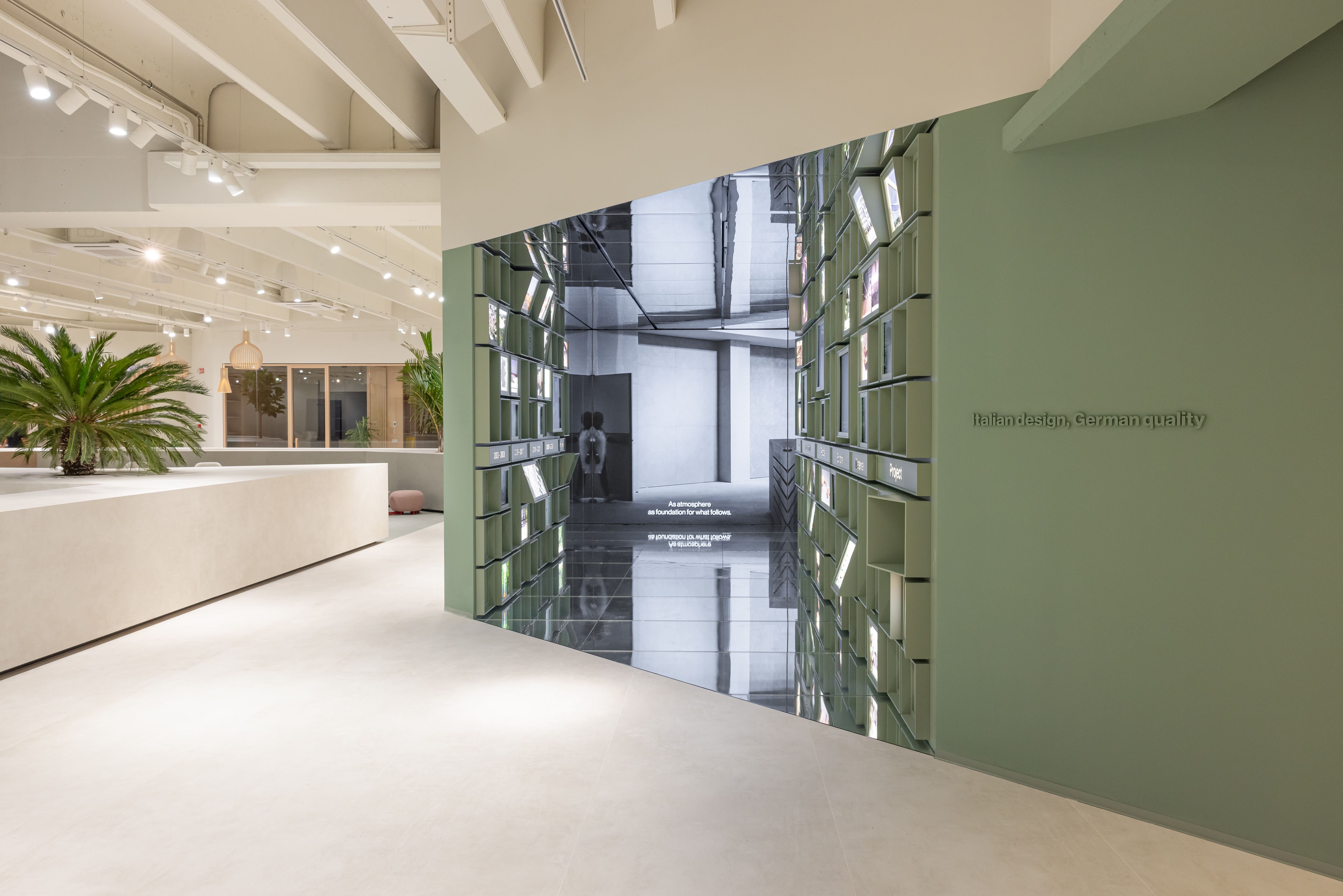 Elegante showroom di piastrelle con pavimento chiaro e moderna installazione di specchi.